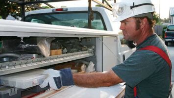 Worker accessing tools in truck.